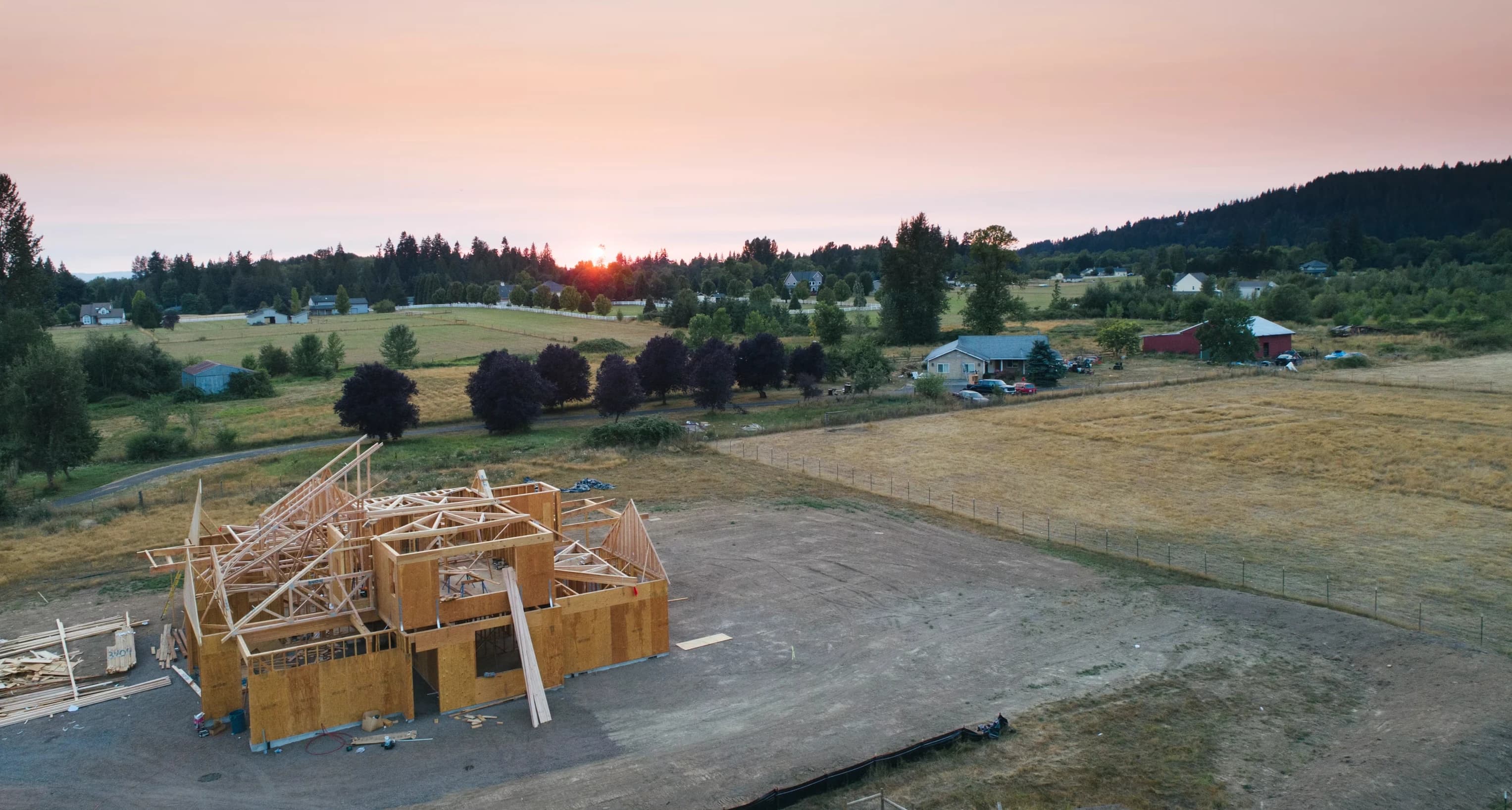 Aerial view of a Kingdom Builders home under construction at sunset